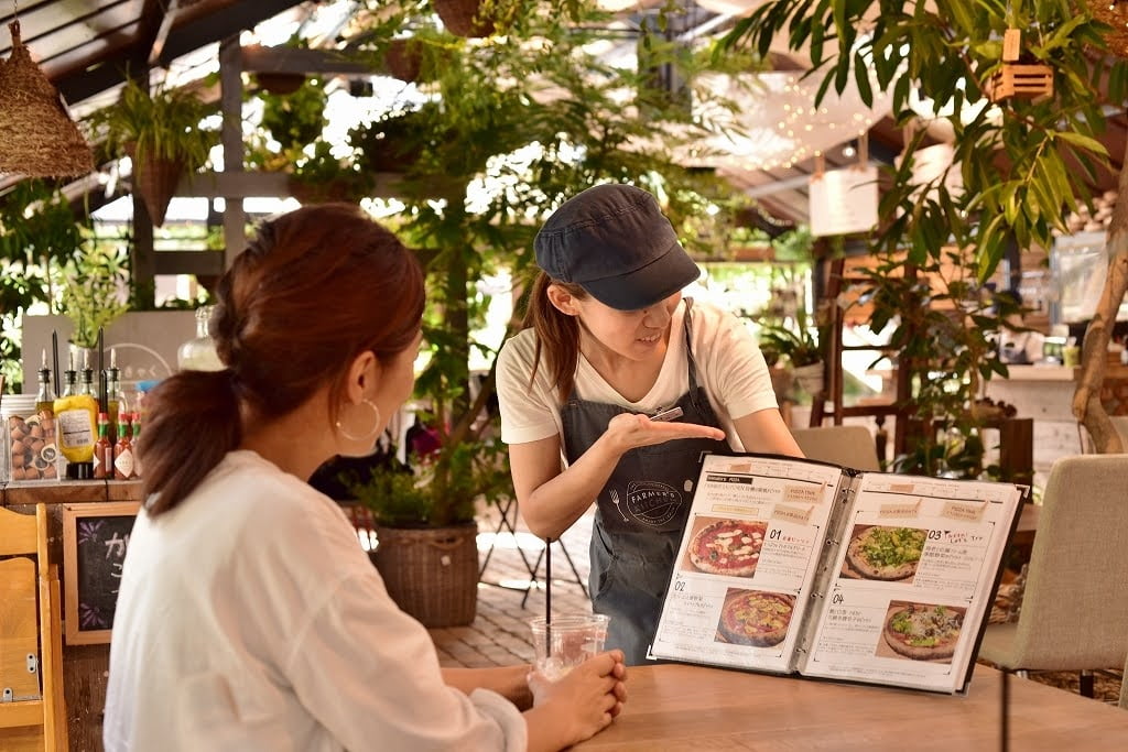 店内で商品カタログを見ながら接客するスタッフの写真